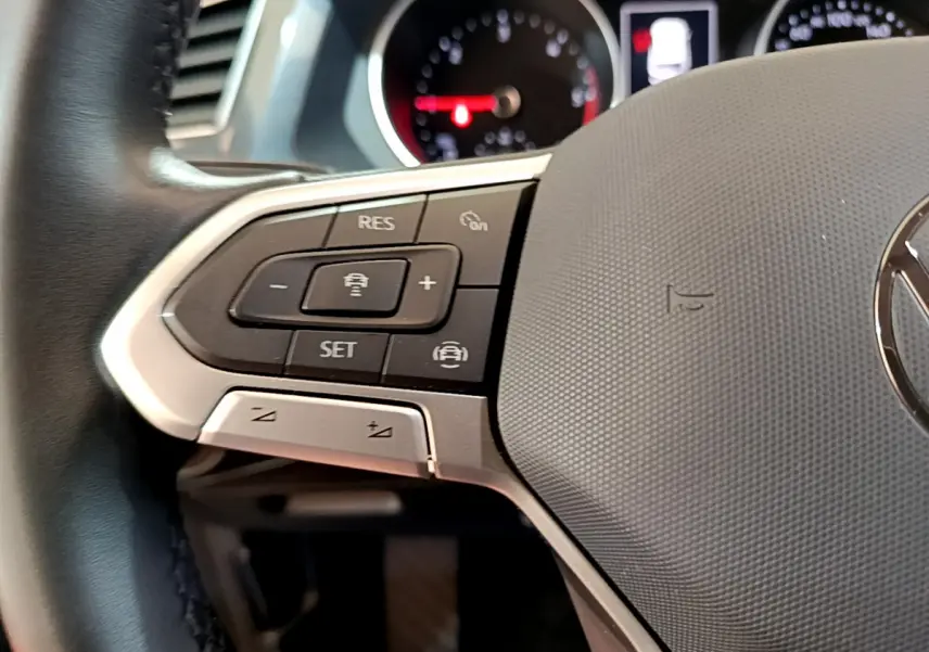 Gros plan sur le volant cuir noir du Volkswagen Tiguan 2.0 TDI 150 DSG7 avec commandes de régulateur de vitesse.