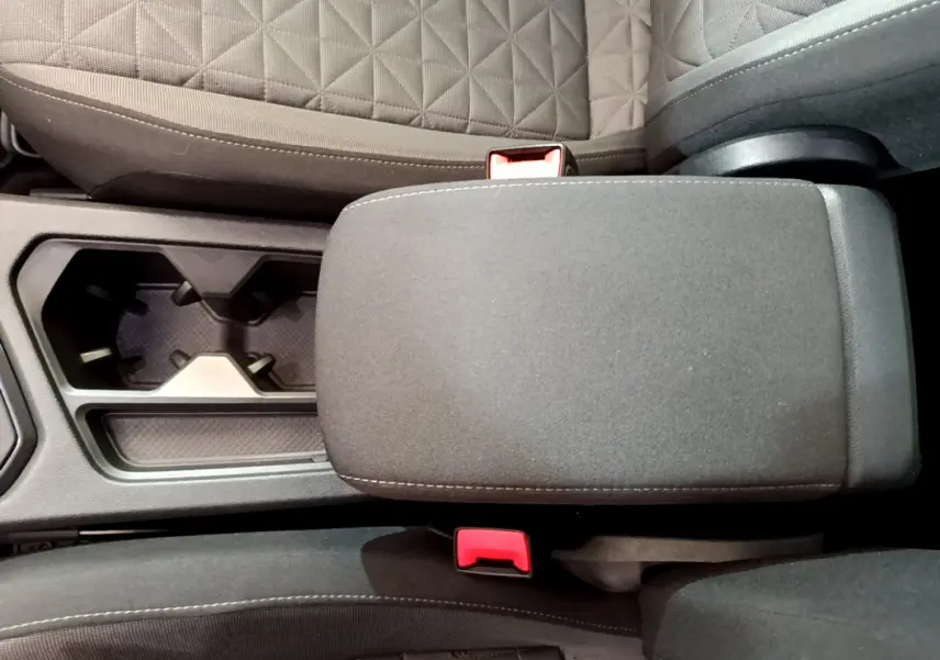 Vue rapprochée de l'accoudoir central gris et porte-gobelets entre les sièges avant du Volkswagen Tiguan 2021.