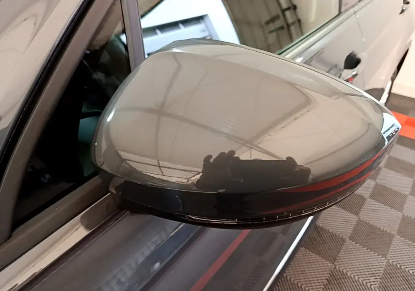 Rétroviseur droit gris clair du Volkswagen Tiguan 2021 avec clignotant LED intégré, vue rapprochée en intérieur.