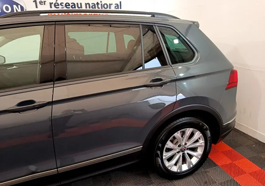 Vue côté droit arrière du Volkswagen Tiguan gris clair 2021 avec jante alliage et feux arrière LED visibles.
