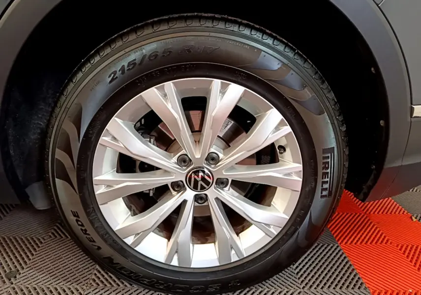 Gros plan sur la roue avant droite du Volkswagen Tiguan gris clair avec jante alliage et pneu Pirelli.