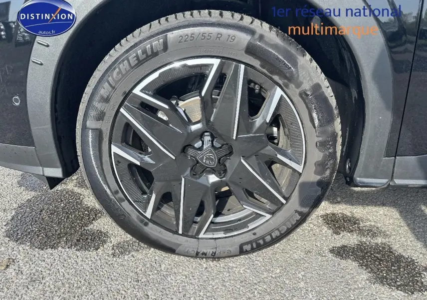 Gros plan sur la roue avant droite noire avec jante alu au design moderne du Peugeot 3008 1.2 hybrid 145 allure 2025.