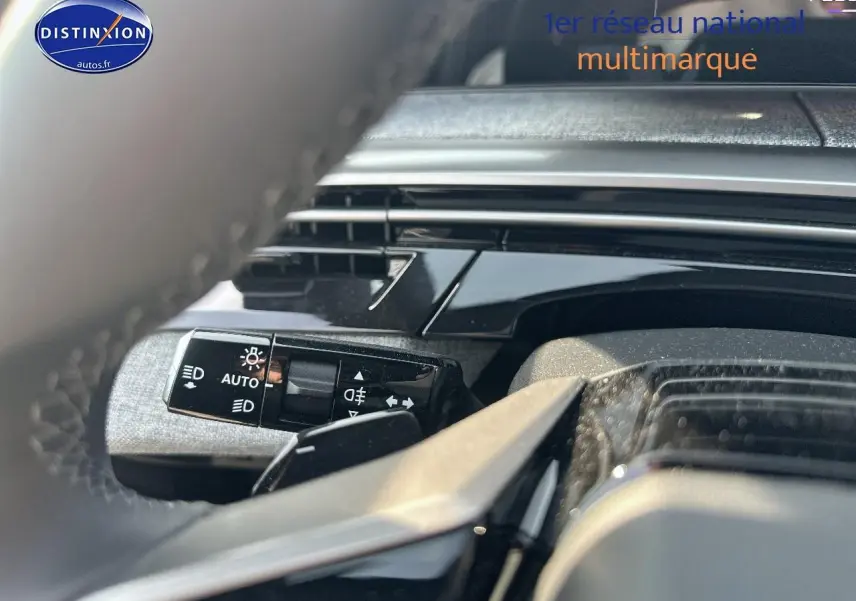 Gros plan sur la commande des phares automatiques côté gauche du volant du Peugeot 3008 noir perla nera 2025.