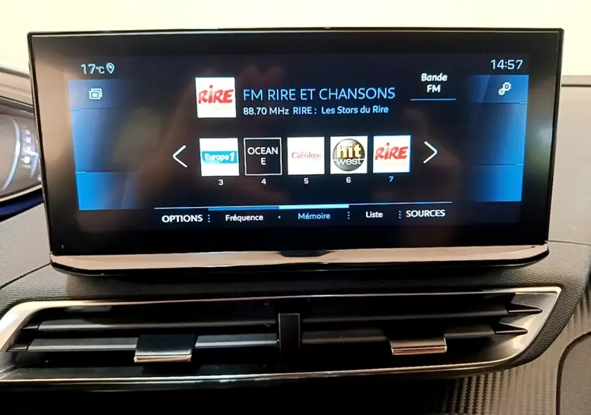 Écran tactile central affichant la radio FM dans l’habitacle du Peugeot 3008 gris foncé, vue de face.