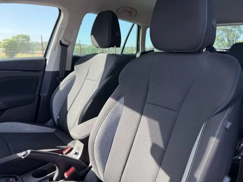 Vue rapprochée des sièges avant gris foncé et clair du Skoda Kamiq 2025, intérieur lumineux côté conducteur.