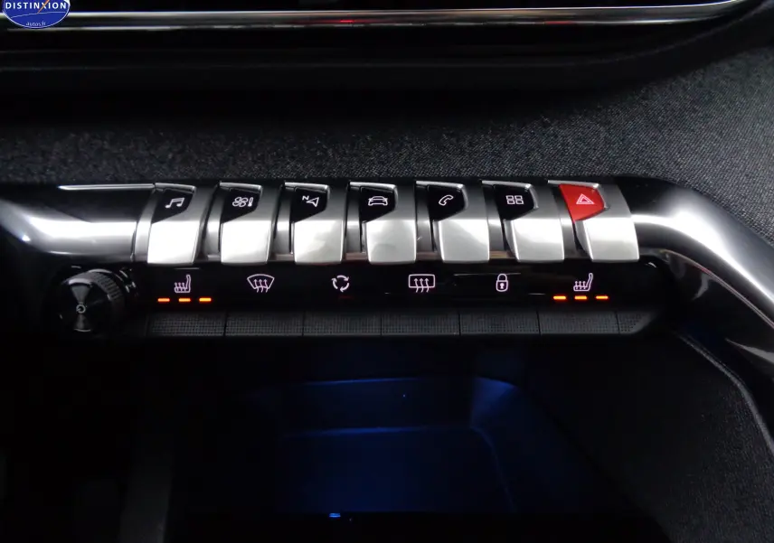 Vue rapprochée des commandes centrales du tableau de bord du Peugeot 3008 gris platinium, avec boutons argentés et éclairage rouge.