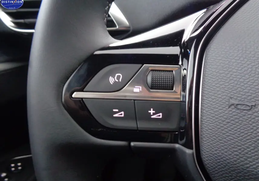 Gros plan sur les commandes de volume et de téléphone intégrées au volant cuir noir du Peugeot 3008 gris platinium 2023.