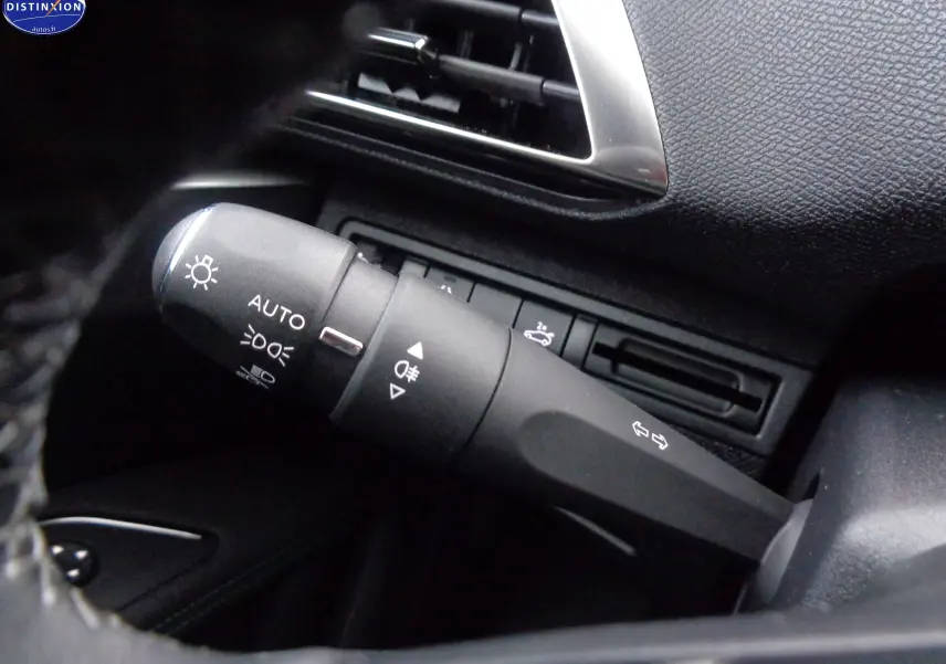 Gros plan sur la commande des feux et clignotants dans l'habitacle noir du Peugeot 3008 gris platinium 2023.