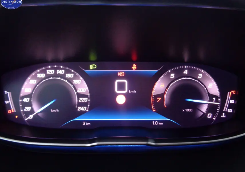 Tableau de bord numérique allumé du Peugeot 3008 gris platinium, affichant vitesse et compte-tours au ralenti.