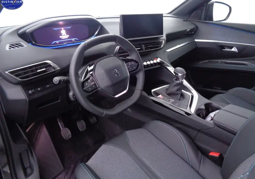 Intérieur du Peugeot 3008 2023 côté conducteur, volant compact, tableau de bord numérique et console centrale avec levier de vitesse manuel.