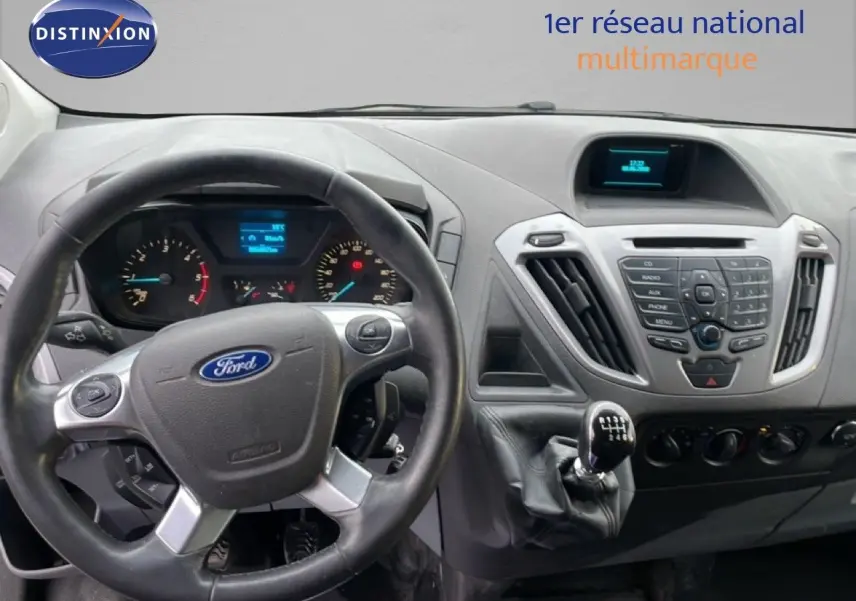 Vue intérieure du tableau de bord du Ford Transit Custom blanc 2016, avec volant et levier de vitesses manuel visibles.