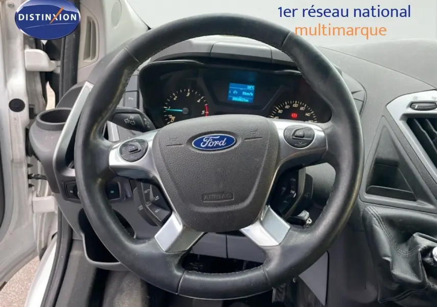 Vue rapprochée du volant Ford noir et tableau de bord du Transit Custom blanc L1H1 2016 avec levier de vitesses manuel.