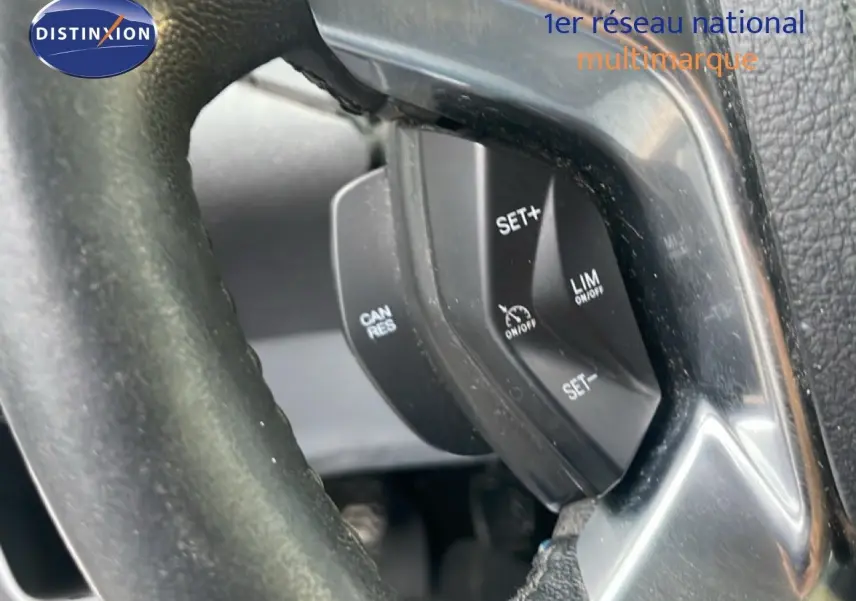 Gros plan sur les commandes de régulateur de vitesse au volant noir du Ford Transit Custom blanc L1H1 2016.