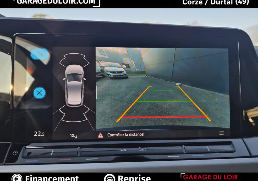 Écran de caméra de recul avec vue arrière et capteurs de distance sur Volkswagen Golf bleu 2023.