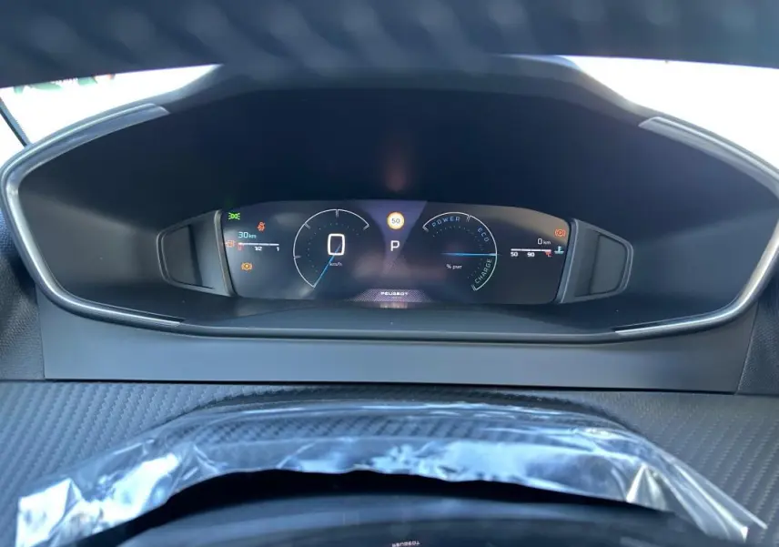 Vue rapprochée du cockpit numérique de la Peugeot 208 Hybrid 110, affichage digital clair et moderne.