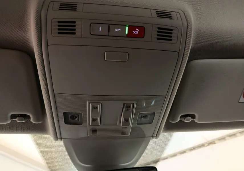 Vue intérieure du plafond de la Volkswagen Taigo gris foncé 2023, avec commandes d’éclairage et bouton SOS éclairé.