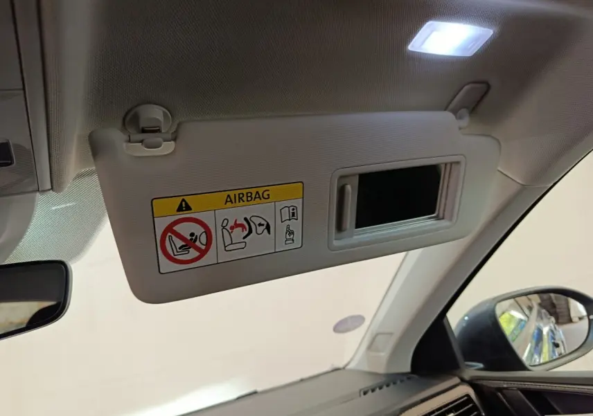 Vue intérieure du pare-soleil côté conducteur avec miroir et avertissement airbag dans un Volkswagen Taigo 2023.