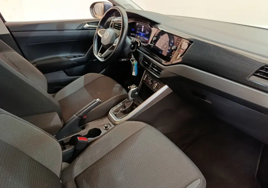 Intérieur avant droit du Volkswagen Taigo gris foncé 2023, avec tableau de bord numérique et écran tactile central.