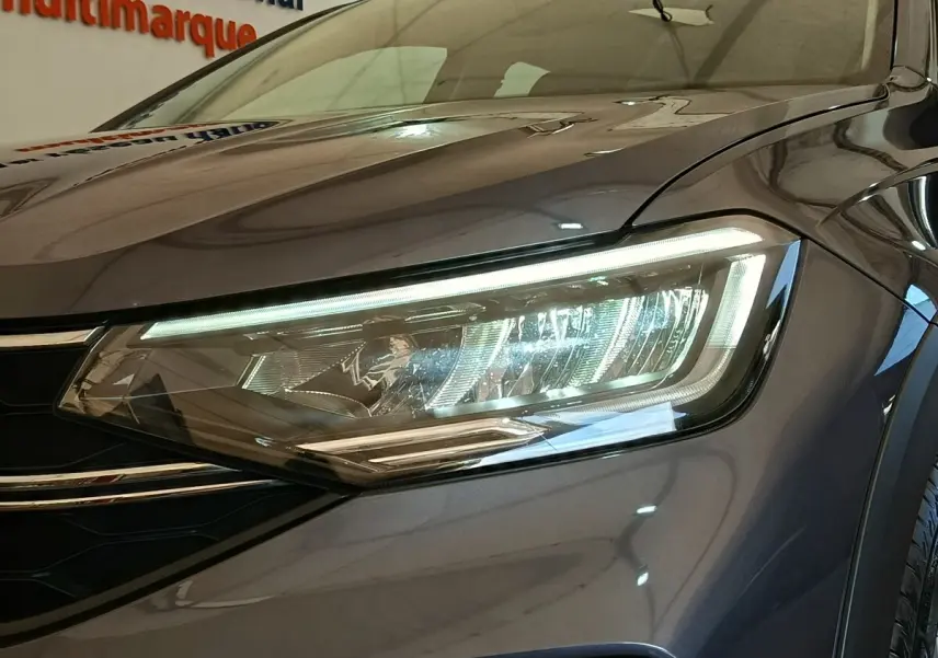 Gros plan sur le phare avant droit du Volkswagen Taigo gris foncé 2023, mettant en valeur son design LED moderne.