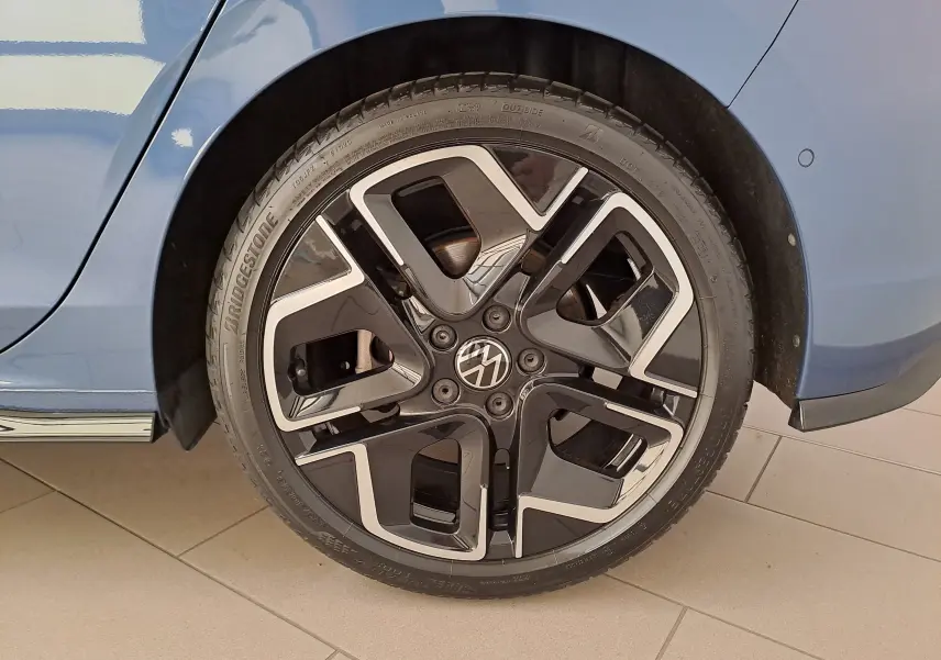 Gros plan sur la roue avant droite de la Volkswagen Golf 1.5 eTSI 150 DSG7 R-Line Edition en bleu Anémone, jante noire et argent.