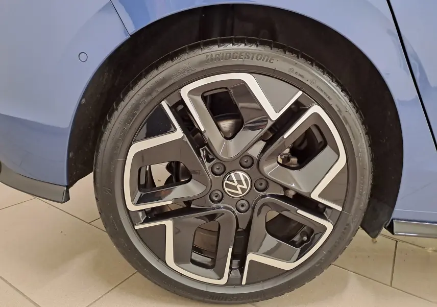 Gros plan sur la roue avant gauche d'une Volkswagen Golf Bleu Anémone avec jante alliage R-Line au design moderne.
