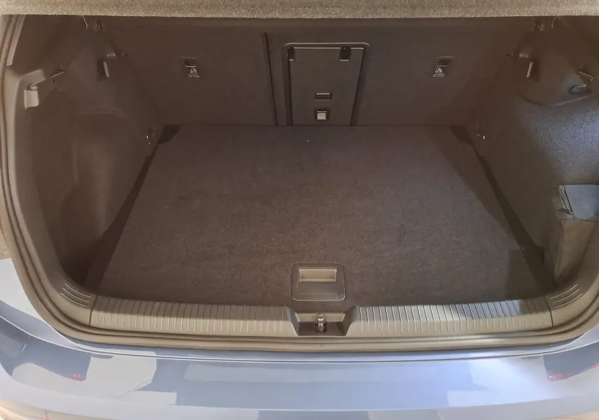 Coffre ouvert vu de l'arrière d'une Volkswagen Golf 1.5 eTSI 150 DSG7 R-Line bleu Anémone avec intérieur de coffre noir.