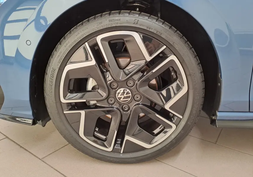 Gros plan sur la roue avant droite de la Volkswagen Golf Bleu Anémone avec jante alliage R-Line au design moderne.