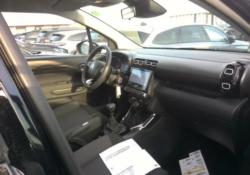 Intérieur noir du Citroën C3 Aircross 2024, vue côté conducteur avec tableau de bord et écran tactile central.