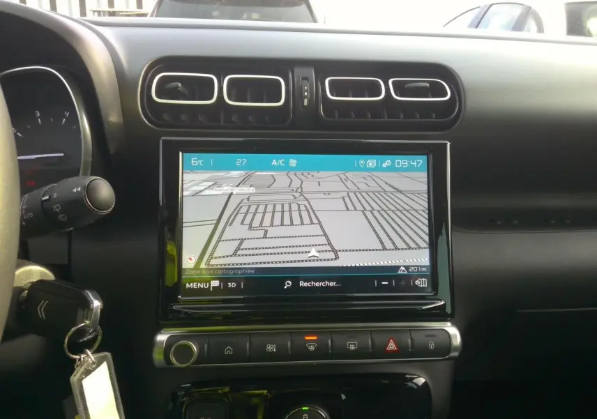 Vue intérieure centrée sur l'écran tactile de navigation et les aérateurs du tableau de bord noir du Citroën C3 Aircross.