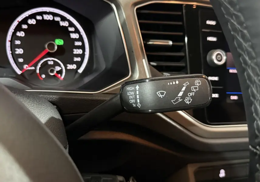 Gros plan sur la manette d'essuie-glace à gauche du volant dans l'habitacle du Volkswagen T-Roc blanc 2020.