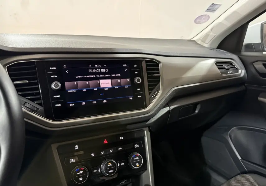 Intérieur du Volkswagen T-Roc blanc 2020, tableau de bord avec écran tactile 8 pouces et commandes climatisation visibles côté passager.