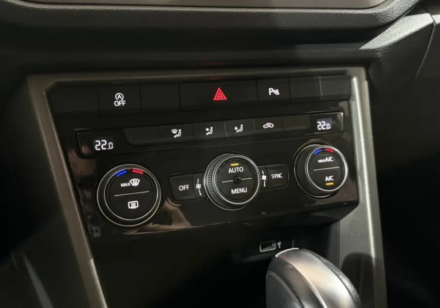 Panneau de commande de climatisation digitale du Volkswagen T-Roc 1.5 TSI blanc, avec réglages à 22°C visibles.