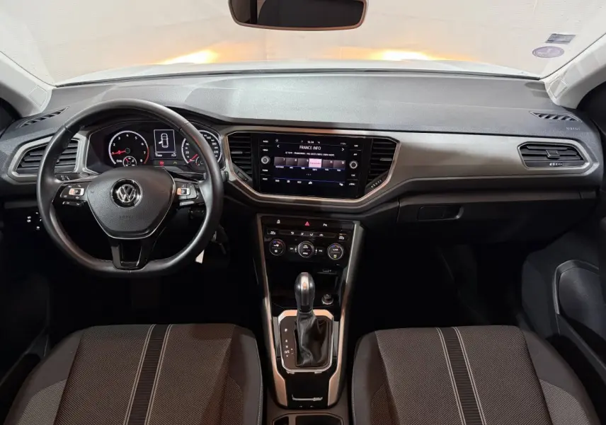 Intérieur du Volkswagen T-Roc 2020, tableau de bord et console centrale avec écran tactile et volant cuir noir.