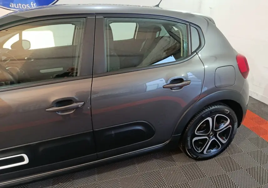 Vue latérale droite d'une Citroën C3 gris foncé 2024 avec jantes noires et inserts noirs sur les portes.