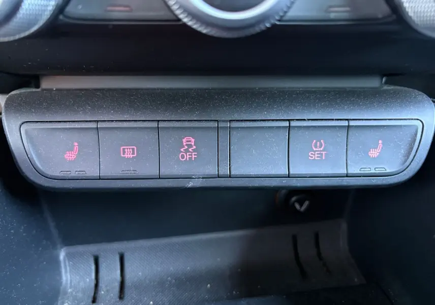 Gros plan sur les boutons de commande du tableau de bord de l'Audi A1 Sportback grise, avec sièges chauffants activés.