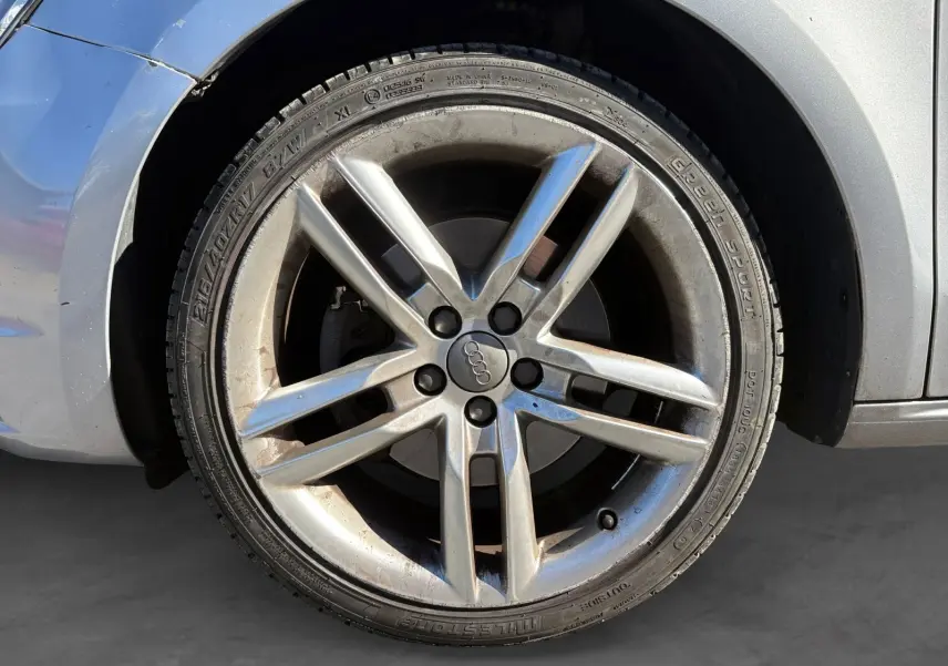 Gros plan sur la jante alliage grise de l'Audi A1 Sportback 1.4 TFSI 122 S-Line, avec logo Audi au centre.