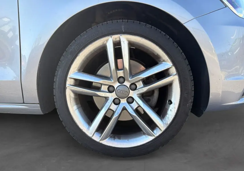 Gros plan sur la roue avant droite grise d’une Audi A1 Sportback 2014 avec jante alliage cinq branches.