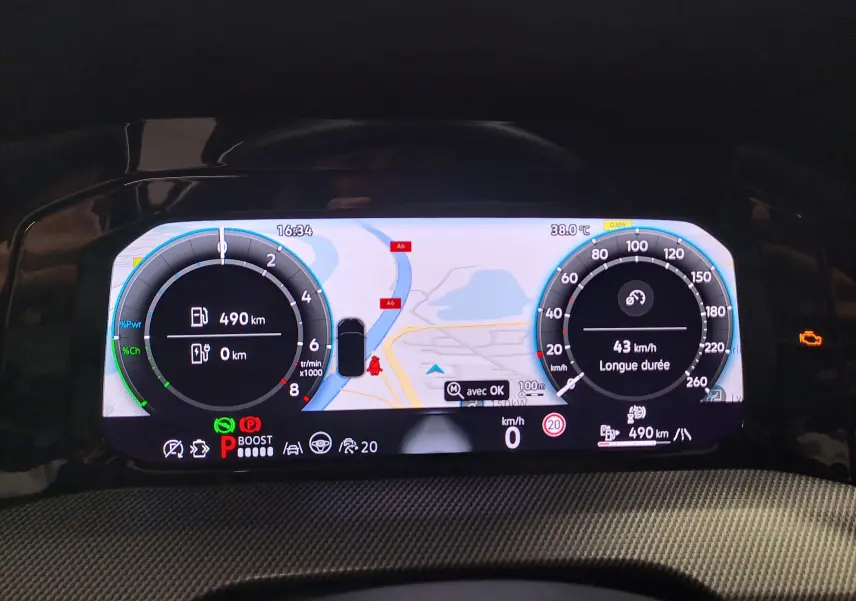 Tableau de bord numérique de la Volkswagen Golf 1.5 eHybrid 2025 affichant la navigation et les compteurs en mode hybride.