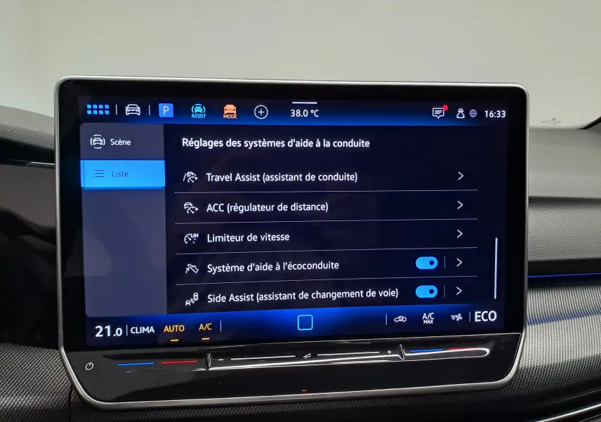 Écran tactile central du Volkswagen Golf 1.5 eHybrid 2025 affichant les réglages des aides à la conduite, intérieur noir.