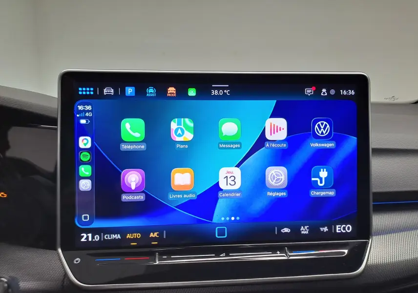 Écran tactile central de la Volkswagen Golf 1.5 eHybrid 2025 affichant les applications connectées et la climatisation à 21°C.
