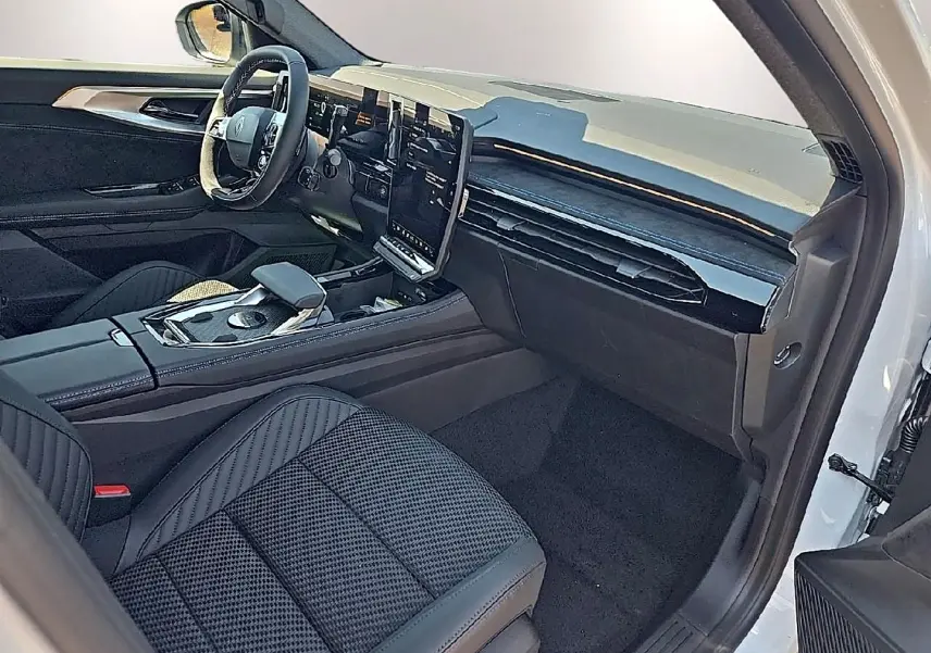 Vue intérieure côté passager du Renault Austral blanc nacré, avec sièges en tissu carbone et tableau de bord moderne noir.