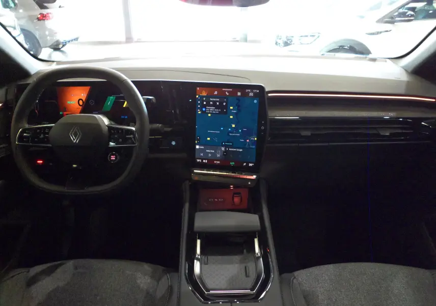 Vue intérieure avant du tableau de bord de la Renault Rafale E-Tech avec écran tactile central et volant multifonction.