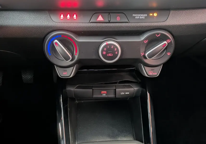 Gros plan sur les commandes de climatisation et la prise USB du tableau de bord du KIA STONIC blanc 2022.