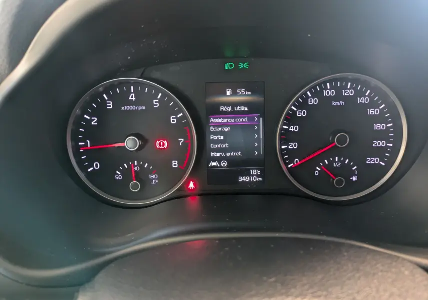 Vue rapprochée du tableau de bord du Kia Stonic blanc, affichant compte-tours, vitesse et écran central des réglages.