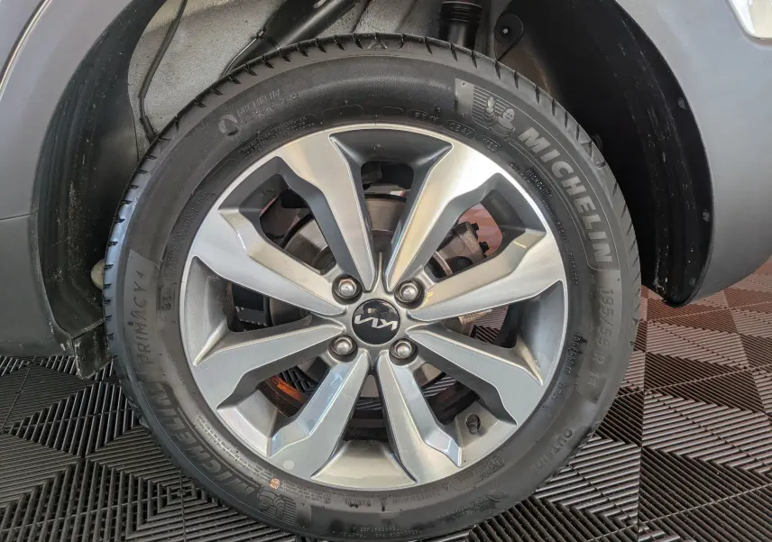 Gros plan sur la roue arrière droite d'un KIA Stonic blanc 2022, montrant le pneu Michelin et l'arche de roue noire.