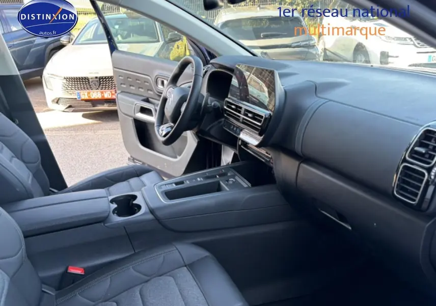 Vue intérieure côté conducteur du Citroën C5 Aircross 2025, montrant tableau de bord et sièges gris foncé.