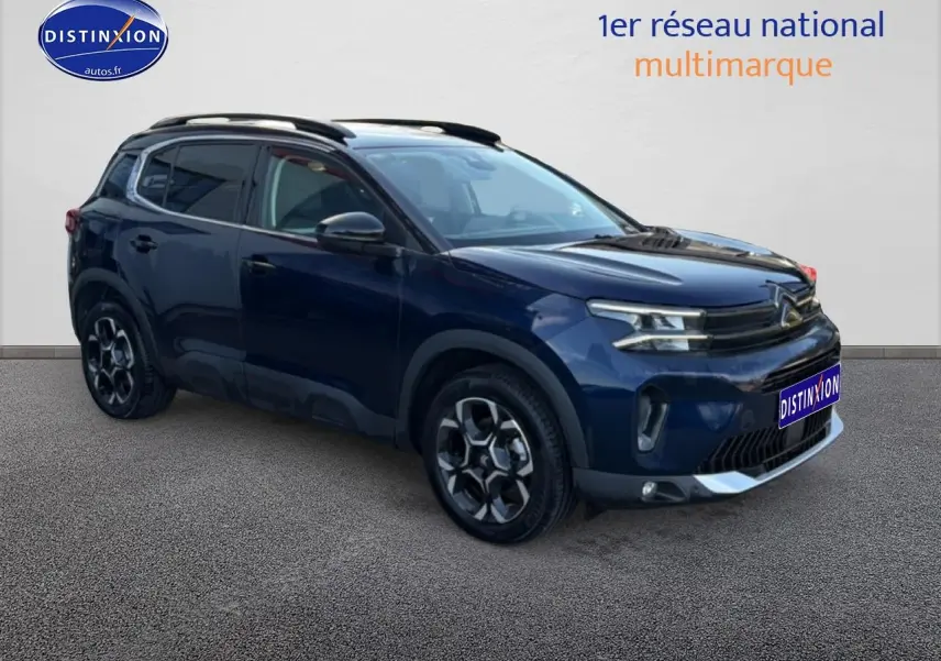Citroën C5 Aircross bleu eclipse en 3/4 avant droit, avec jantes alu et barres de toit noires visibles.