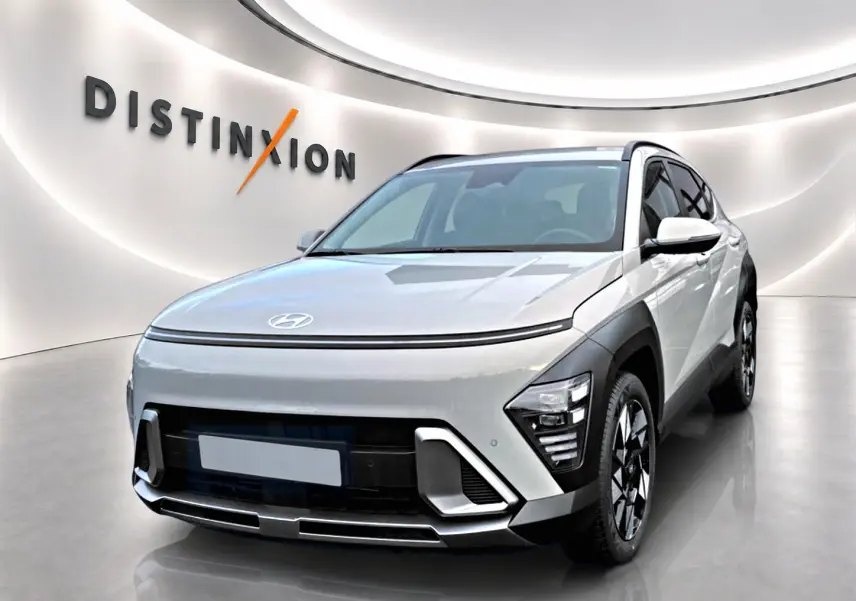 Vue 3/4 avant d'un Hyundai Kona gris avec calandre fermée et jantes alliage noires et argentées dans un showroom.