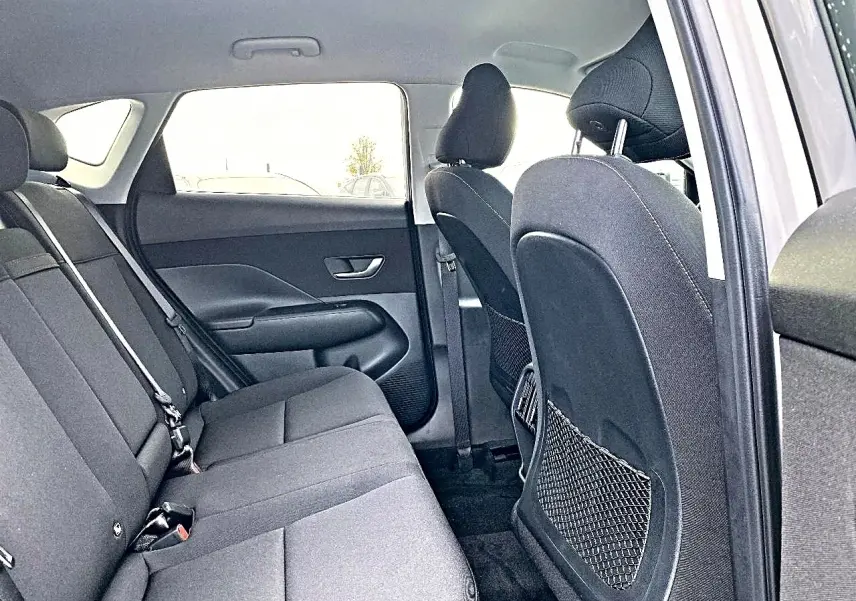 Vue intérieure côté droit montrant la banquette arrière grise et les dossiers des sièges avant du Hyundai Kona 2025.