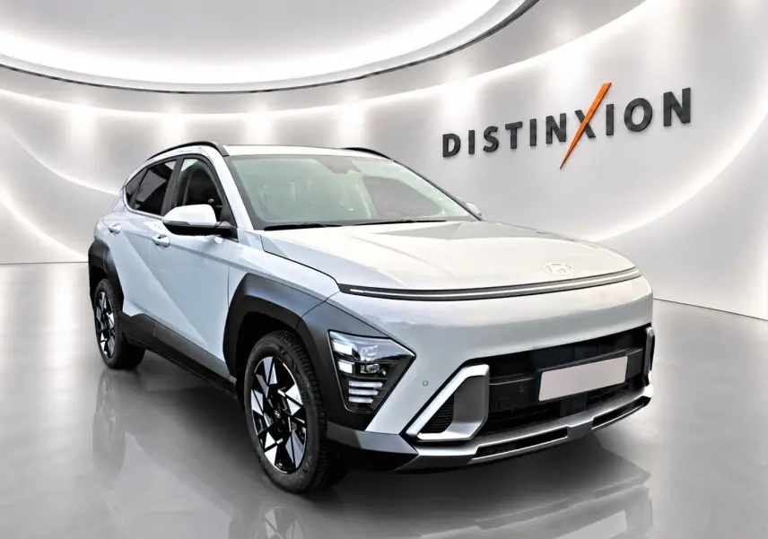 Hyundai Kona gris 2025 en 3/4 avant droit avec jantes alliage et protections noires contrastées.